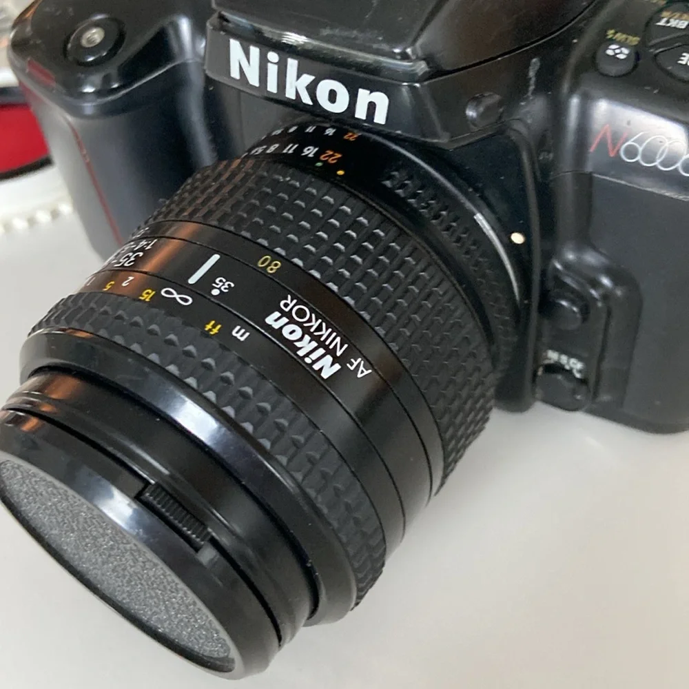 Nikon N6006 AF camera with lenses and leather bag.